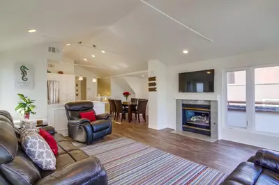 a living room with a couch and a fireplace at Stunning beach home located between bay and beach with Ocean View Patio in San Diego