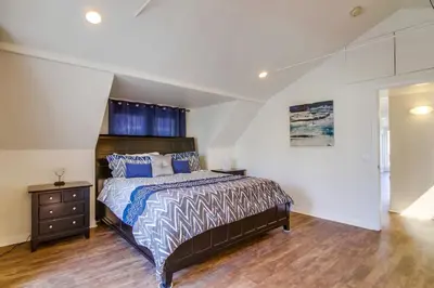 a bedroom with a large bed with blue pillows at Stunning beach home located between bay and beach with Ocean View Patio in San Diego