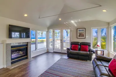 a living room with a couch and a fireplace at Stunning beach home located between bay and beach with Ocean View Patio in San Diego