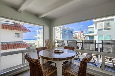 a room with a table and chairs on a balcony at South Shore Gem with Ocean View, Patio, BBQ in San Diego