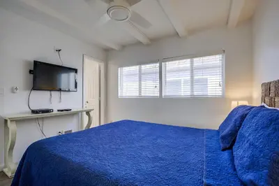 a bedroom with a blue bed and a flat screen tv at South Shore Gem with Ocean View, Patio, BBQ in San Diego
