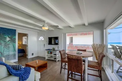 a living room with a table and chairs and a couch at South Shore Gem with Ocean View, Patio, BBQ in San Diego