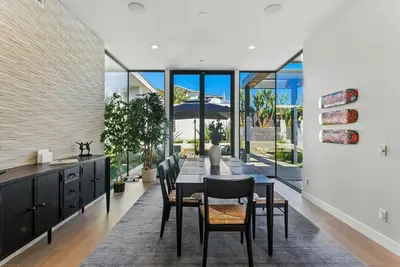 a dining room with a table and chairs and large windows at Luxury Stay with Pool, Spa, Fire Pit, Outdoor Lounge & Stunning Ocean Views, Encinitas Retreat in Encinitas