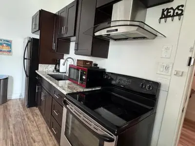 a kitchen with a black stove and a microwave at Walk everywhere heart Gaslamp in San Diego
