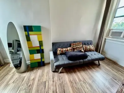 a living room with a blue couch and a mirror at Walk everywhere heart Gaslamp in San Diego