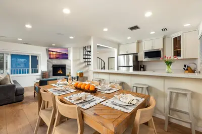 a kitchen and dining room with a wooden table and chairs at Stunning OB Ocean View Stay in San Diego
