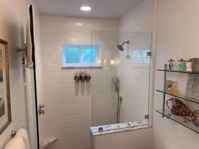 a shower with a glass door in a bathroom at La Jolla Carriage House in San Diego