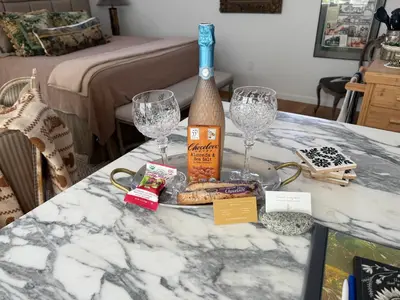 a table with two wine glasses and a bottle on it at La Jolla Carriage House in San Diego