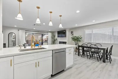 a kitchen and dining room with white cabinets and a table at Wellness Bnb - Your San Diego Retreat in San Diego