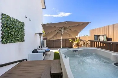 a hot tub on a patio with an umbrella at Wellness Bnb - Your San Diego Retreat in San Diego