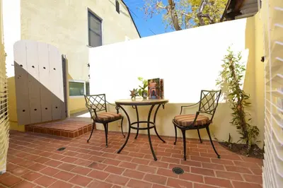 a patio with a table and chairs on a brick patio at Hidden Casita with Private Deck & Patio in San Diego