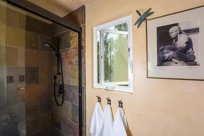 a bathroom with a shower and towels on a wall at Hidden Casita with Private Deck & Patio in San Diego