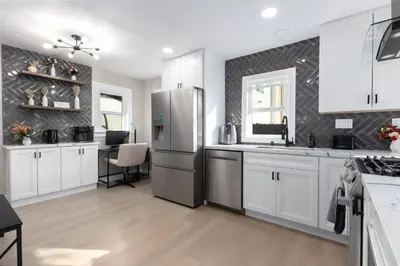 a kitchen with white cabinets and a stainless steel refrigerator at Modern Getaway Near Downtown – Family Friendly in San Diego