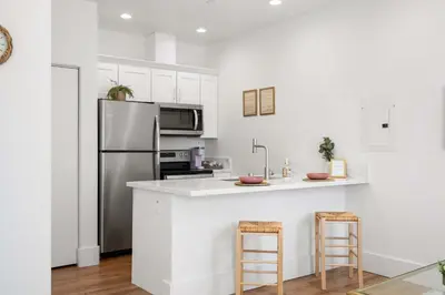 a kitchen with a refrigerator and a counter with stools at Luxury Oasis Compound with Hot Tub with 3 Homes in Escondido