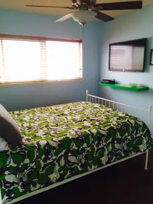 a bedroom with a bed with a green and white blanket at 6BR Beach House w/ Bikes/Fire pit/BBQ/Easy Parking in Newport Beach