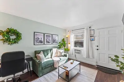 a living room with a green couch and a table at Colorful & Cozy Oasis in North Park Walk to Restaurants, Bars, and Breweries in San Diego
