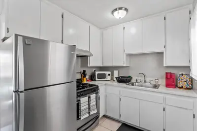 a kitchen with white cabinets and a stainless steel refrigerator at Stylish & Comfy Gem in North Park, Walk to Restaurants, Bars, and Breweries in San Diego