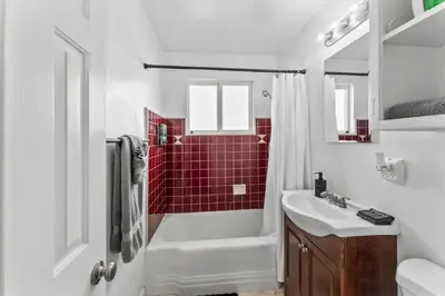 a bathroom with a white sink and red tiles at Stylish & Comfy Gem in North Park, Walk to Restaurants, Bars, and Breweries in San Diego