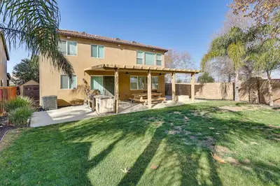 a house with a large yard in front of it at Spacious Menifee Home with Patio, 9 Mi to Lake! in Menifee