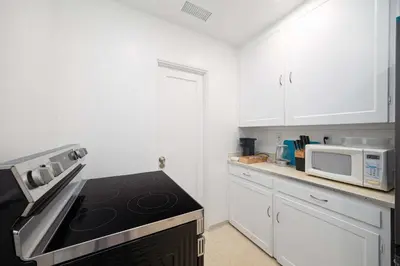 a kitchen with white cabinets and a stove top oven at 10 Min to the Beach Colorful Home Huge Yard in San Diego