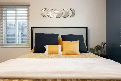 a bed with yellow and blue pillows on it at 10 Min to the Beach Colorful Home Huge Yard in San Diego