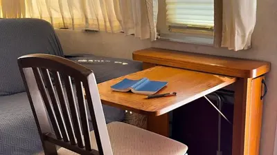 a small wooden table with a chair and a window at Retro Star-Wagon, Ocean View at Studios in Oceanside