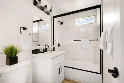a white bathroom with a shower and a sink at Sunny Coastal Escape Large 3BR Home Sleeps 8 in San Diego