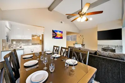 a dining room with a table and a kitchen at Perfect Newport Beach Location With Balcony Spa II in Newport Beach