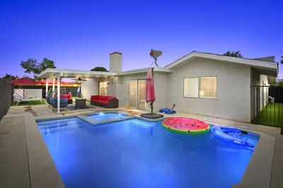 a swimming pool in front of a house at Heated Pool - Jacuzzi - Firepit - Game Room in Hemet