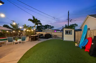 a backyard with a lawn with a surfboard on it at Cozy Room with Hot Tub, Pool, Sauna & Gym Near Beach in Oceanside