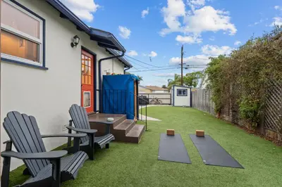 a small backyard with two chairs and a table and two benches at Cozy Room with Hot Tub, Pool, Sauna & Gym Near Beach in Oceanside