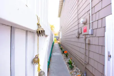 a hallway with bells on the side of a building at Charming Garden Cottage with Full Kitchen Walk to La Jolla Village & Beaches in San Diego