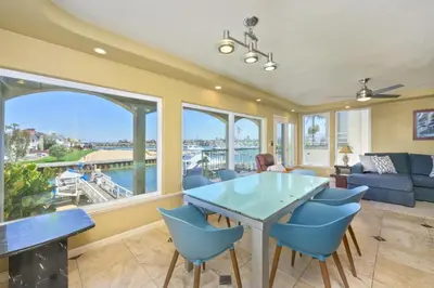 a living room with a table and chairs and a large window at Bay Breeze in Newport Beach