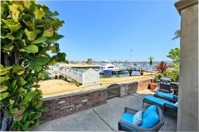 a patio with blue chairs and a view of a marina at Bay Breeze in Newport Beach