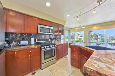 a kitchen with wooden cabinets and a stove top oven at Bay Breeze in Newport Beach