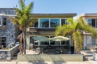 a house with palm trees in front of it at Salt & Sand II in Newport Beach