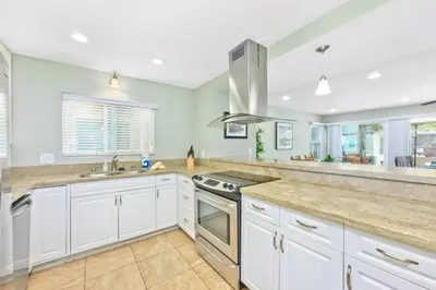 a kitchen with white cabinets and a sink at Salt & Sand I in Newport Beach