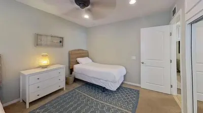 a bedroom with a bed and a dresser with a lamp at Salt & Sand I in Newport Beach