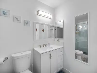a white bathroom with a toilet and a sink at Recently updated home close to La Jolla & Del Mar- 2 bedrooms home in San Diego