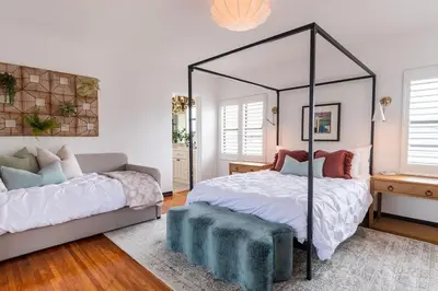 a bedroom with a canopy bed and a couch at Epic Resort Villa: Pool Spa Firepit View Games in San Diego