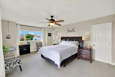a bedroom with a bed and a ceiling fan at Oceanview Oasis with Roofdeck Hot Tub in Carlsbad