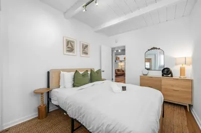 a white bedroom with a large bed and a mirror at Modern Eclectic 2BR Near Petco, Balboa Park & Zoo in San Diego