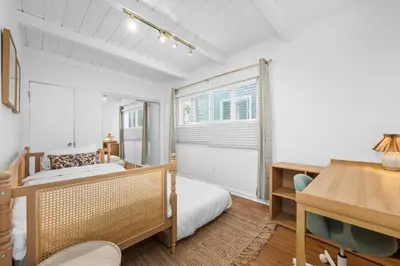 a bedroom with a bed and a desk and a window at Modern Eclectic 2BR Near Petco, Balboa Park & Zoo in San Diego