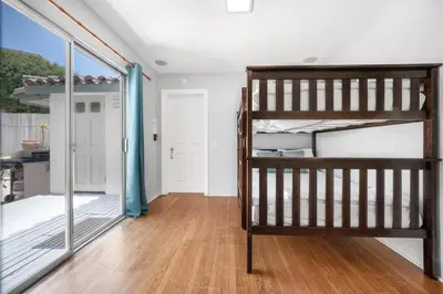 a bedroom with a bunk bed and a sliding glass door at 2BR-2 mins to Ocean-Sleeps 8-Pets in San Diego