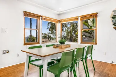 a dining room with a table and green chairs at 2BR-2 mins to Ocean-Sleeps 8-Pets in San Diego