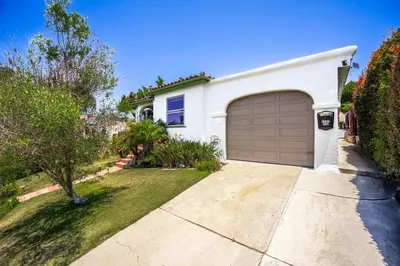 a white house with a garage in a yard at 2BR-2 mins to Ocean-Sleeps 8-Pets in San Diego