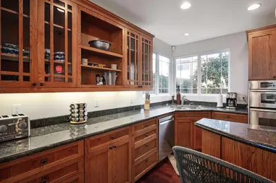 a kitchen with wooden cabinets and a counter top at Windansea Hideaway Rooftop Ocean Views in San Diego