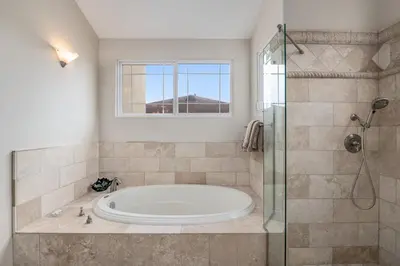 a bathroom with a tub and a glass shower at Windansea Hideaway Rooftop Ocean Views in San Diego