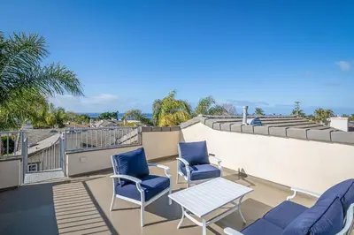 a patio with chairs and a table on a balcony at Windansea Hideaway Rooftop Ocean Views in San Diego