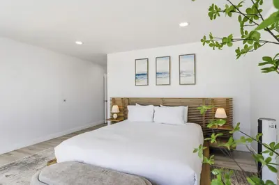 a bedroom with a white bed and a couch at Sea Glass Beach Road Villa On the SAND Luxury and relaxation in Dana Point